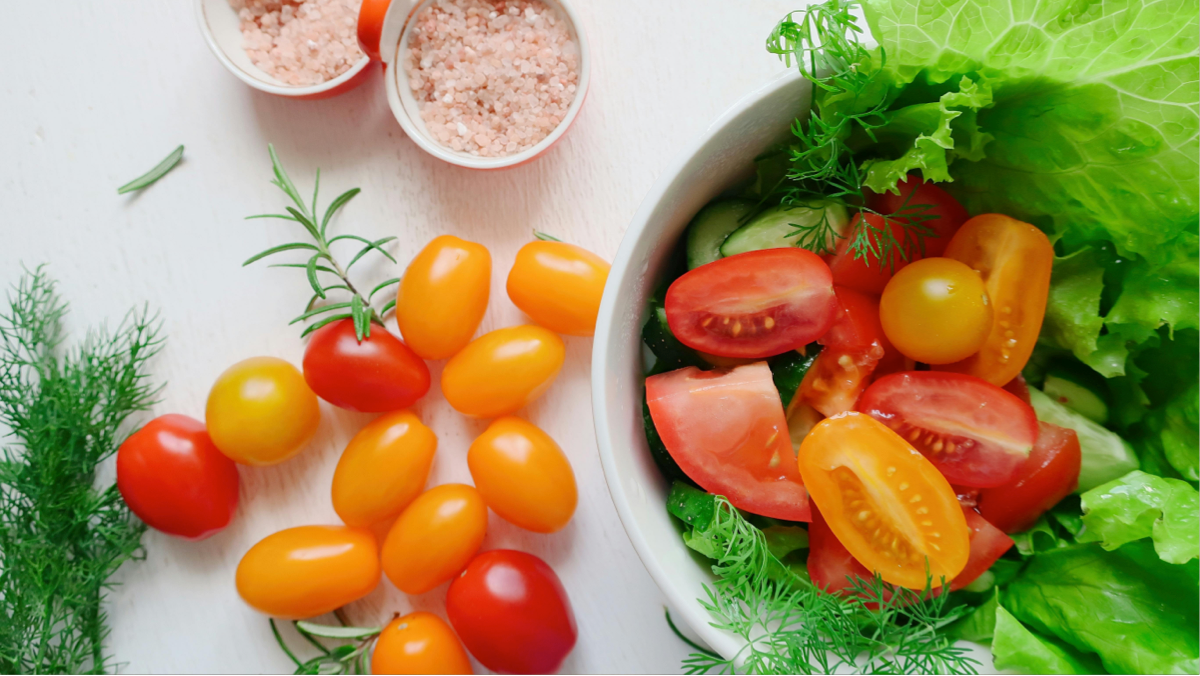 Fresh green salad with cucumbers, tomatoes and herbs