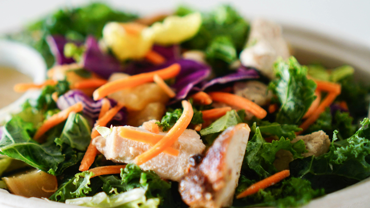 Rotisserie chicken salad with greens, tomatoes, cucumber and garlic sauce
