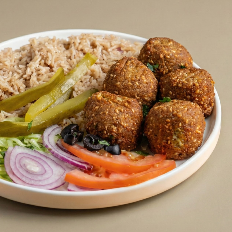 Falafel over rice with chopped salad and tahini drizzle